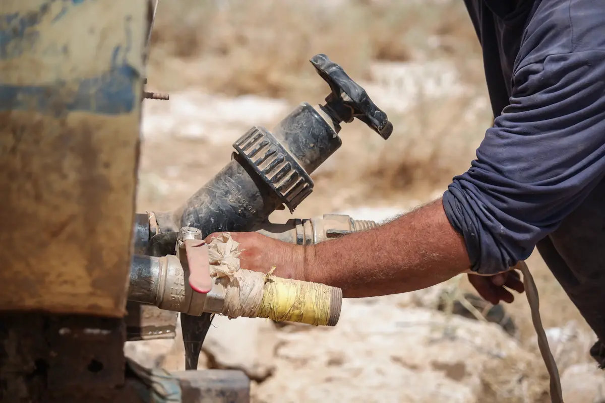Worker repairing a valve on an outdoor water supply line